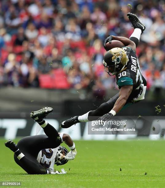 Corey Grant of the Jacksonville Jaguars is tackled Tony Jefferson of the Baltimore Ravens during the NFL International Series match between Baltimore...