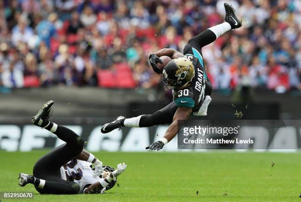 Corey Grant of the Jacksonville Jaguars is tackled Tony Jefferson of the Baltimore Ravens during the NFL International Series match between Baltimore...