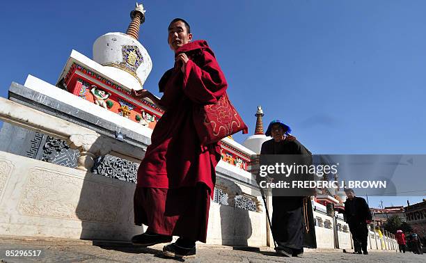 Tibetan Buddhist monk and pilgrim circle a row of stupas at the Kumbum Monastery outside of Xining on March 8, 2009 in northwest China's Qinghai...