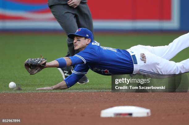 Darwin Barney of the Toronto Blue Jays dives but cannot snag a line-drive single by Jacoby Ellsbury of the New York Yankees in the seventh inning...