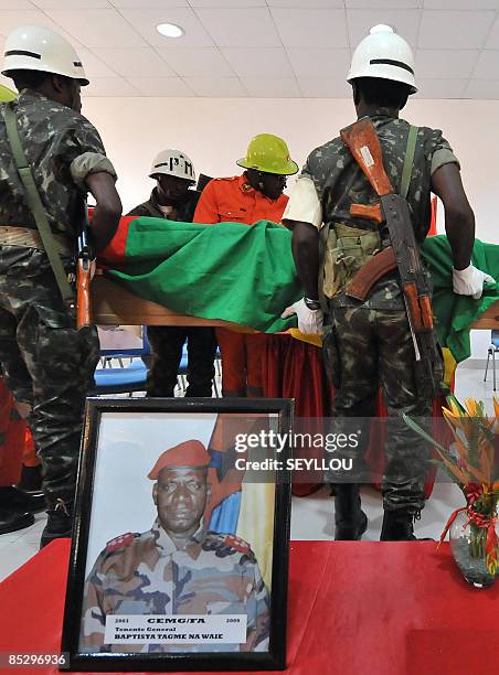 Soldiers carry on March 8, 209 the coffin of Guinea-Bissau army chief, General Batista Tagme Na Waie, near his portrait in Bissau during a state...