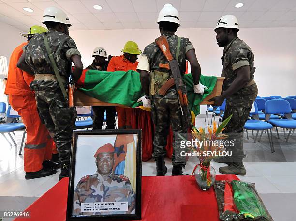 Soldiers carry on March 8, 209 the coffin of Guinea-Bissau army chief, General Batista Tagme Na Waie, near his portrait in Bissau during a state...