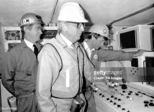 Trade and Industry Secretary Lord Young presses the start button on the tunnel boring machine in the south marine running tunnel at Dover, watched by...