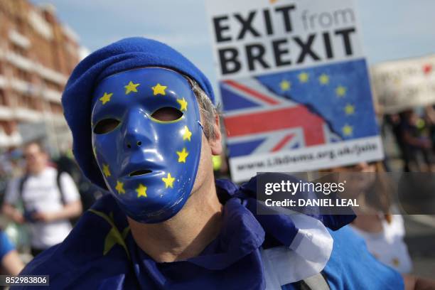 Protesters march along the seafront holding placards and waving European and Union flags in Brighton on September 24 on a march against Brexit. -...