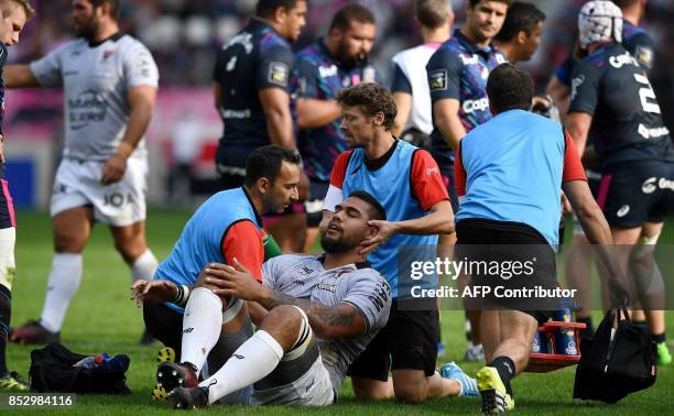 Toulon's French lock Romain Taofifenua is helped by medical staff during the French Top 14 rugby union match between Stade Francais and Toulon at the...