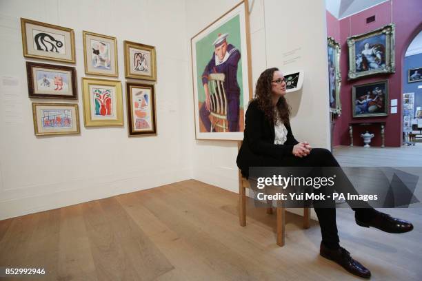 Gallery staff member seated next to works by David Hockney, during a press preview of the exhibition 'Hockney, Printmaker', at Dulwich Picture...