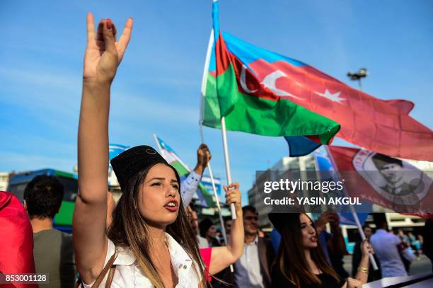 Woman flashes "grey wolf" nationalist sign as protesters wave Turkish and Iraqi Turkmen flags on September 24, 2017 in Istanbul, during a...