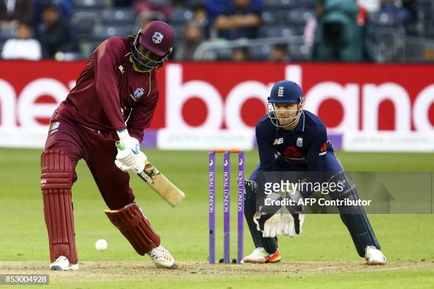 West Indies' Chris Gayle plays a shot as England's Jos Buttler keeps wicket during the third one day international cricket match played between...
