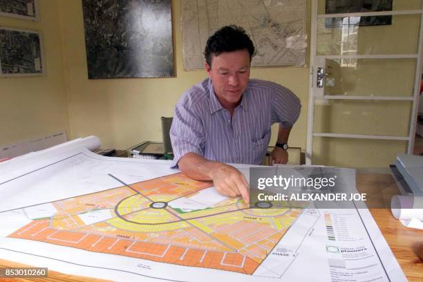 Rijk Damckuets, the owner of Bunks Hill farm that Zimbabwean war veterans occupied, looks at the plans 13 April 2000 of the shopping village that he...