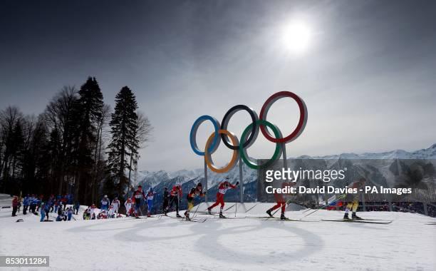 Eventual winner Switzerland's Dario Cologna lies second as the field passes the Olympic rings in the Men's 15km + 15km Skiathlon during the 2014...