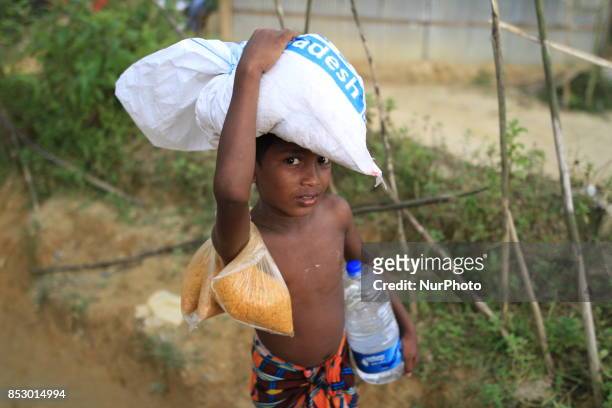 Rohingya boy collects aid at a refugee camp in Ukhia, Bangladesh on September 23, 2017. About 430,000 Rohingya people have fleeing violence erupted...