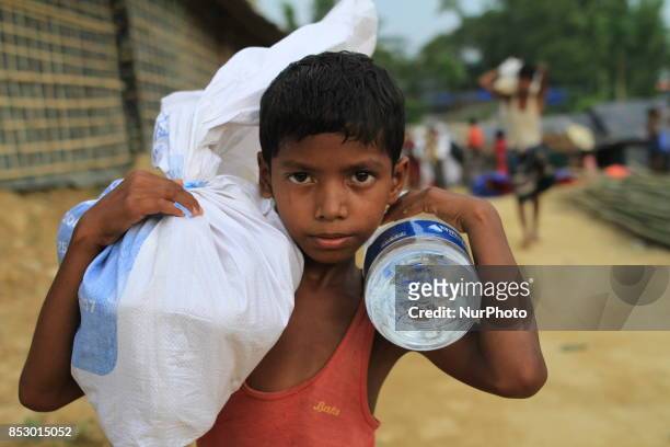 Rohingya boy collects aid at a refugee camp in Ukhia, Bangladesh on September 23, 2017. About 430,000 Rohingya people have fleeing violence erupted...