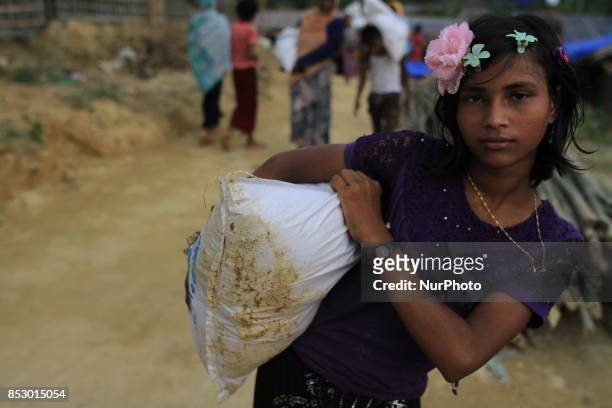 Rohingya girl collects aid at a refugee camp in Ukhia, Bangladesh on September 23, 2017. About 430,000 Rohingya people have fleeing violence erupted...