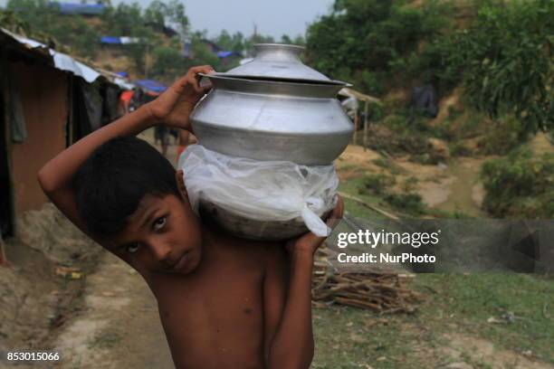 Rohingya boy collects aid at a refugee camp in Ukhia, Bangladesh on September 23, 2017. About 430,000 Rohingya people have fleeing violence erupted...