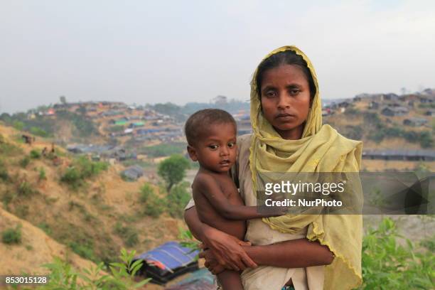 Rohingya woman holds her son at a Rohingya refugee camp in Ukhia, Bangladesh on September 23, 2017. About 430,000 Rohingya people have fleeing...