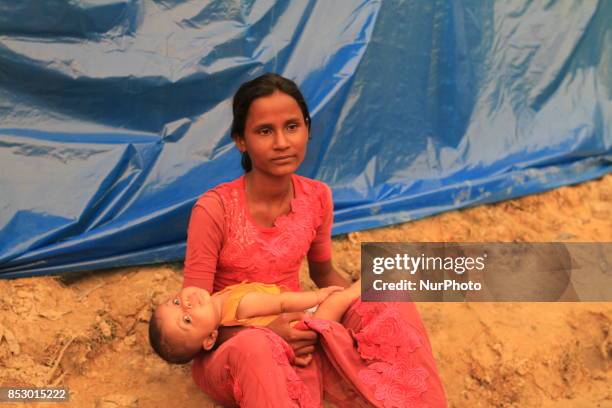 Rohingya woman holds her son at a Rohingya refugee camp in Ukhia, Bangladesh on September 23, 2017. About 430,000 Rohingya people have fleeing...