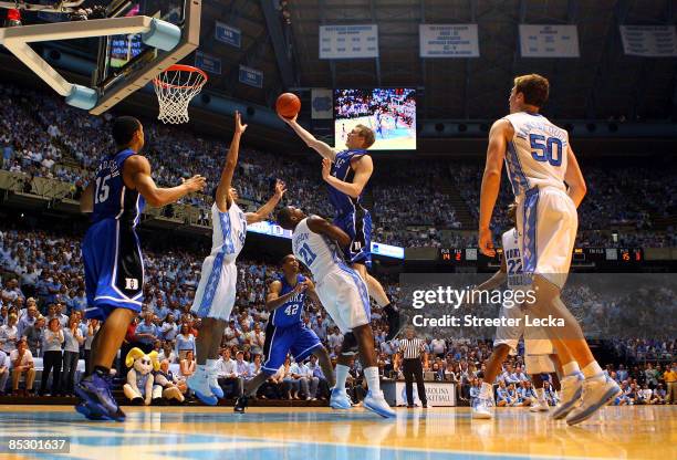 Kyle Singler of the Duke Blue Devils charges over Deon Thompson of the North Carolina Tar Heels during their game at the Dean E. Smith Center on...