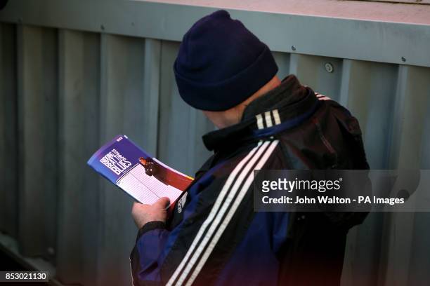 Birmingham City fan reads the match day programme at the Valley