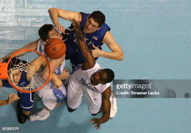 Teammates Brian Zoubek and teammate David McClure of the Duke Blue Devils battle for a rebound with teammates Bobby Frasor and Ed Davis of the North...