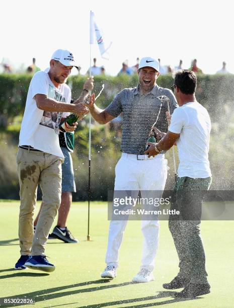 Lucas Bjerregaard of Denmark celebrates victory with Jeff Winther and Thorbjorn Olesen on the 18th green during day four of the Portugal Masters at...