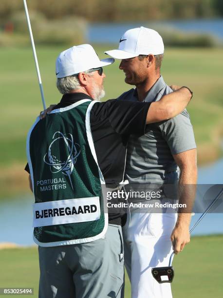 Lucas Bjerregaard of Denmark celebrates victory with his caddie Brian Bo Martin on the 18th green during day four of the Portugal Masters at Dom...