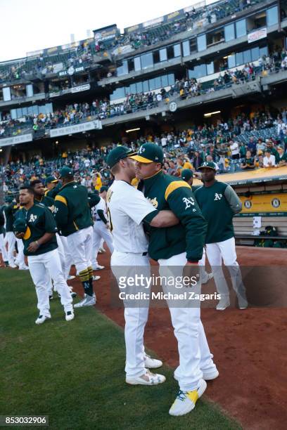 Bruce Maxwell of the Oakland Athletics is embraced after kneeling during the national anthem prior to the game against the Texas Rangers at the...