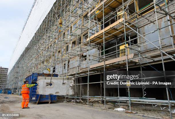 Construction workers lower a concrete panel from empty flats on the Heygate Estate, in Elephant and Castle, in south London, which is in the process...