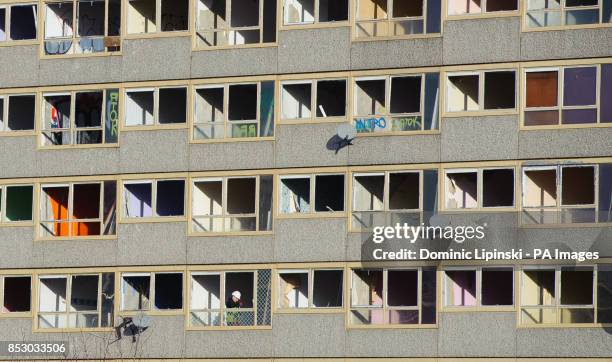 Construction worker in the window of empty flats on the Heygate Estate, in Elephant and Castle, in south London, which is in the process of being...