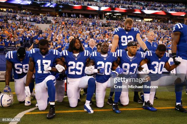 Members of the Indianapolis Colts stand and kneel for the national anthem prior to the start of the game between the Indianapolis Colts and the...