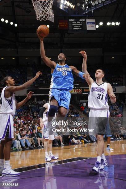 Nene of the Denver Nuggets gets to the basket against Spencer Hawes of the Sacramento Kings on March 8, 2009 at ARCO Arena in Sacramento, California....