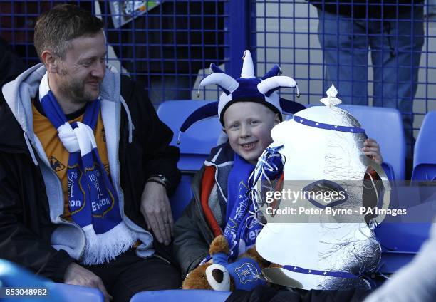 Everton fan holds a homemade FA cup trophy in the stands