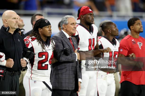 Atlanta Falcons owner Arthur Blank joins arms with his players during the playing of the national anthem prior to the game against the Detroit Lions...