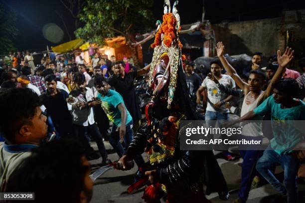 An Indian artist dressed as the Hindu Goddess Kali performs the traditional 'Kali Swang,' organised annually by the Daraganj Ramleela committee,...