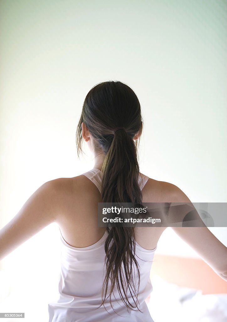 Young woman stretching at home