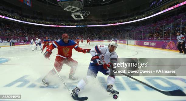Norway's Martin Roymark gets away from Russia's Andrei Markov in the play off match during the 2014 Sochi Olympic Games in Sochi, Russia.