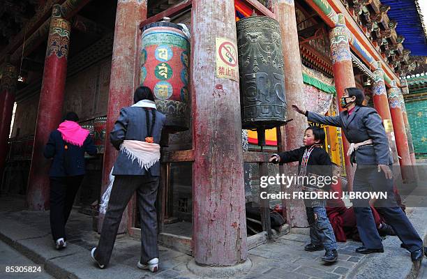 Tibetan Buddhists spin prayer wheels at the Kumbum Monastery outside of Xining on March 8, 2009 in northwest China's Qinghai province, a vast region...