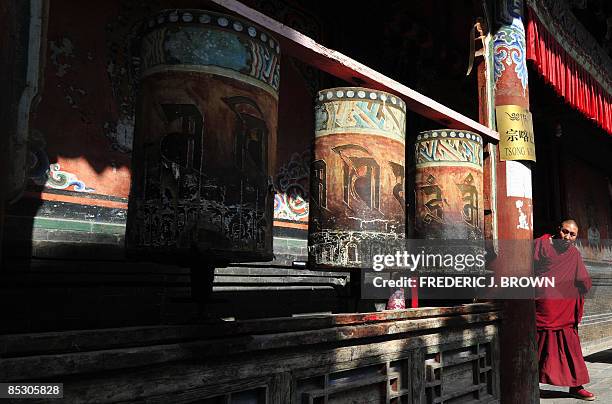 Tibetan Buddhist monk steps out of a prayer hall at the Kumbum Monastery outside of Xining on March 8, 2009 in northwest China's Qinghai province, a...