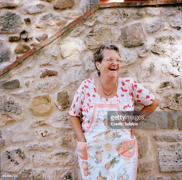 mature woman standing outside house, smiling - cultura italiana foto e immagini stock