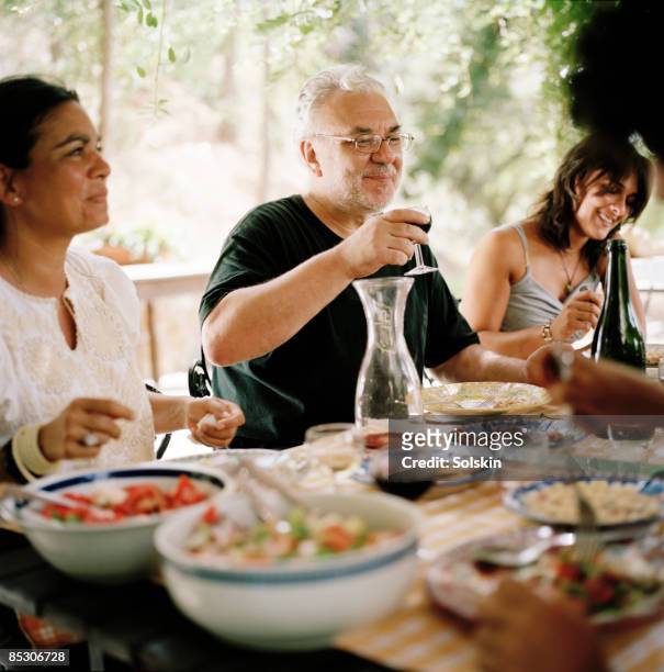 family and friends having garden dinner - happy family eating stock pictures, royalty-free photos & images