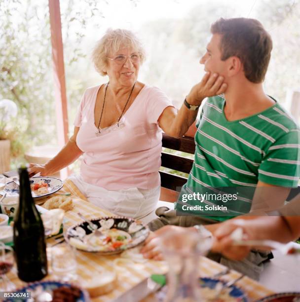 family garden dinner, woman touching mans face - mid volwassen mannen stockfoto's en -beelden