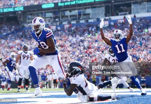 Andre Holmes of the Buffalo Bills scores a touchdown as Bradley Roby of the Denver Broncos attempts to tackle him during the second quarter of an NFL...