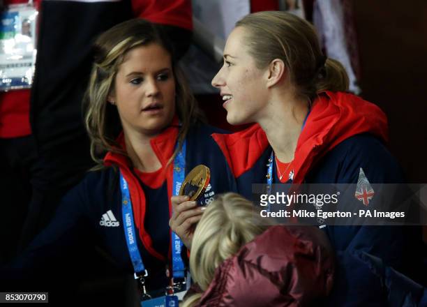 Great Britain's skeleton Gold medalist Lizzie Yarnold shows her gold medal to curlers Vicki Adams and Anna Sloan as they watch the Men's Gold medal...
