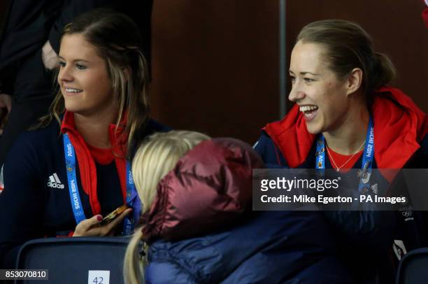 Great Britain's skeleton Gold medalist Lizzie Yarnold shows her gold medal to curlers Vicki Adams and Anna Sloan as they watch the Men's Gold medal...