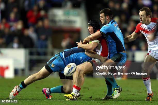 St Helens' Jonny Lomax is tackled by Hull FC's Joe Arundel and Hull FC's Gareth Ellis during the First Utility Super League match at Langtree Park,...