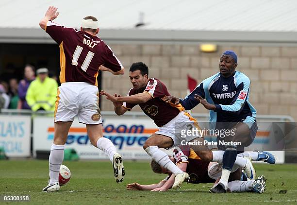Bas Savage of Tranmere Rovers is stopped by Jason Crowe, Mark Hughes and Andy Holt of Northampton Town during the Coca Cola League One Match between...