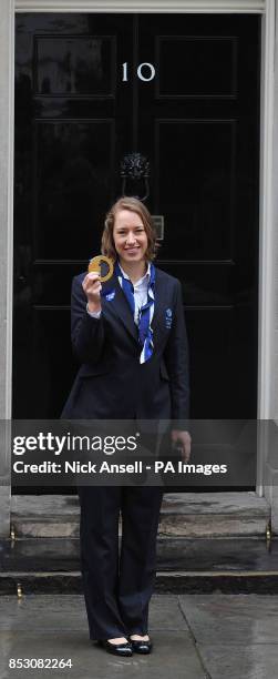 Great Britain's Lizzy Yarnold, gold medal winner of the Women's Skeleton, from the 2014 Sochi Olympics, holds her medal as she stands outside 10...