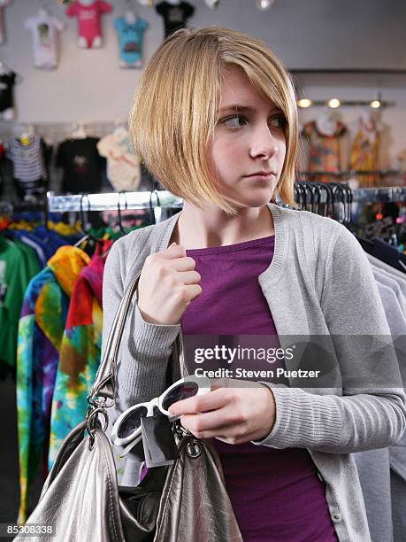 teen girl shoplifting sunglasses - auf frischer tat ertappt stock-fotos und bilder