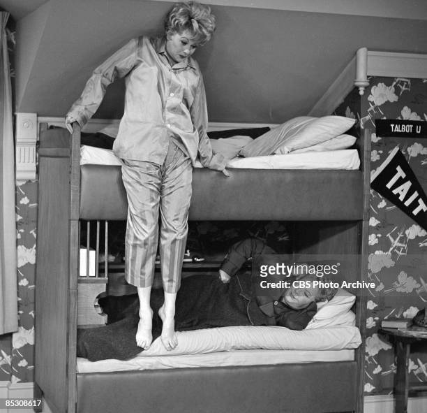 American actress and comedienne Lucille Ball , as Lucille Carmichael, attempts to climb into the top bed of a bunkbed while Vivian Vance , as Vivian...