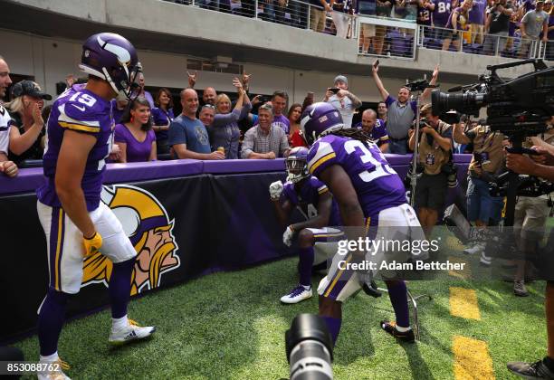 Stefon Diggs of the Minnesota Vikings celebrates a touchdown on the sidelines with teammates Adam Thielen and Dalvin Cook in the second quarter of...