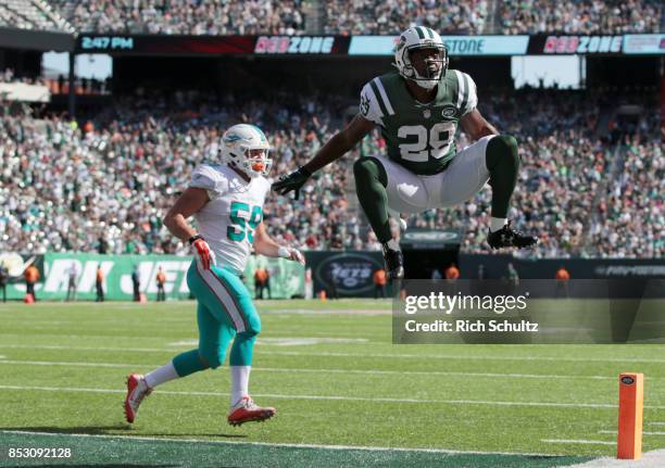 Bilal Powell of the New York Jets jumps into the end zone for a second half touchdown against the Miami Dolphins during an NFL game at MetLife...